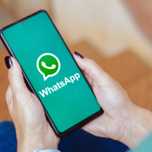 The WhatsApp logo is displayed on a smartphone screen. 