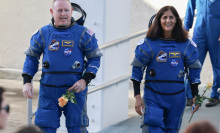 Butch Wilmore and Suni Williams walking in astronaut suits