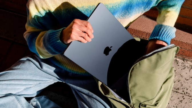 a close-up of a person putting a 15-inch m3 apple macbook air into a backpack