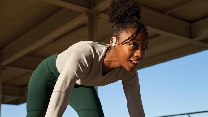 a female runner in the starting spring position wears the jbl endurance peak 3 headphones