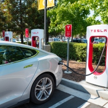 tesla car being charged in a parking lot