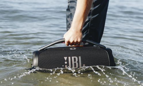 person holding JBL Boombox 3 in ocean