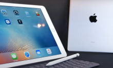 two ipads, one silver, one pink, against a dark background