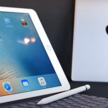 two ipads, one silver, one pink, against a dark background