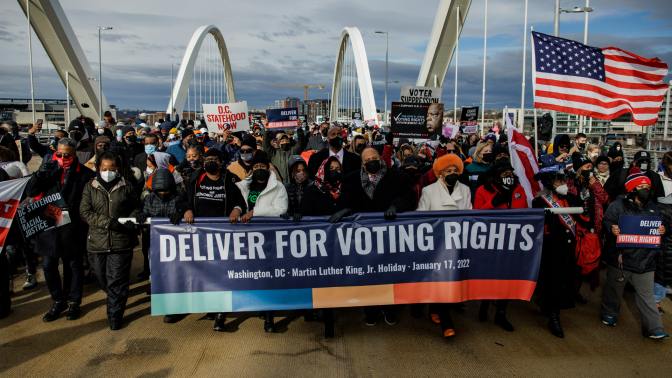 Voting rights activists march across the Frederick Douglass Memorial Bridge for Dr. Martin Luther King Day on January 17, 2022.