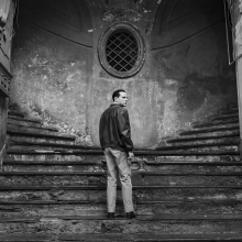 A man stands on an Italian public staircase, looking over his shoulder.