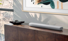 long, gray soundbar sitting on credenza with Samsung Frame TV on the wall behind it