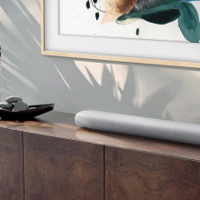 long, gray soundbar sitting on credenza with Samsung Frame TV on the wall behind it