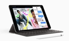 apple pencil and ninth gen ipad propped open with imessage and magazine on its screen 