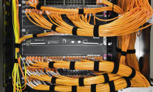 Many orange cables connected to a server box.