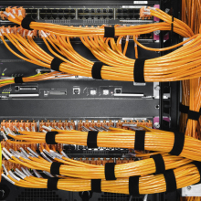 Many orange cables connected to a server box.