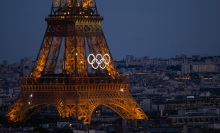 eiffel tower lit up at night with olympic rings on it