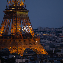 eiffel tower lit up at night with olympic rings on it