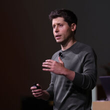 OpenAI CEO Sam Altman speaking onstage at the company's developer conference 