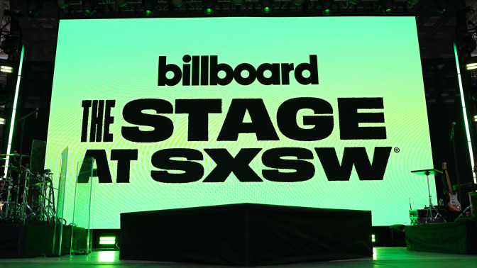 A glowing green screen on a stage that reads "Billboard. The stage at SXSW."