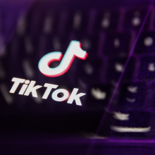 A distorted TikTok logo overlaid on a keyboard.