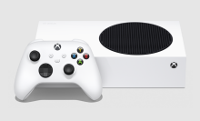 an xbox series s lying on its side next to an xbox wireless controller