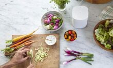 White speaker next to a cutting board with vegetables on it