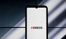 The XVideos logo is being displayed on a smartphone screen