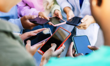 Teen friends watching social media content on smartphone app. 