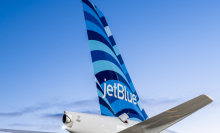 Plane with JetBlue logo on tail flying through sky