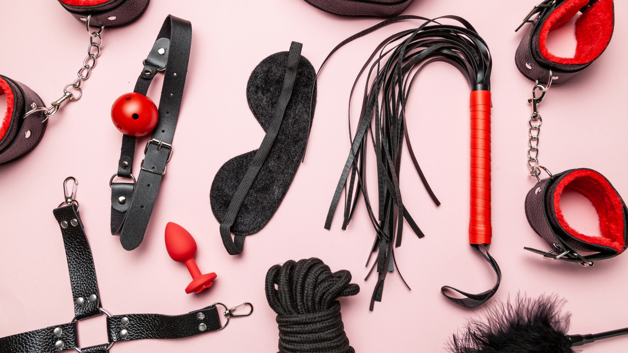 A set of BDSM toys including a whip, gag and leather blindfold.