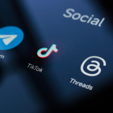 A close up of a phone screen showing the Telegram, TikTok, and Threads apps. 