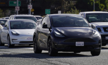 Tesla vehicles drive on the street on February 2, 2024 in San Bruno, California. 