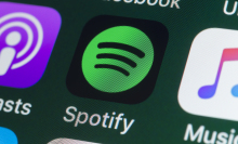 he buttons of the music streaming app Spotify, surrounded by Podcasts, Apple Music, Facebook and other apps on the screen of an iPhone.