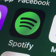 he buttons of the music streaming app Spotify, surrounded by Podcasts, Apple Music, Facebook and other apps on the screen of an iPhone.