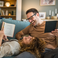 Adult couple man and woman Caucasian husband and wife in a relationship real book hold books on the sofa bed at home in the apartment reading leisure bonding family concept real people copy space