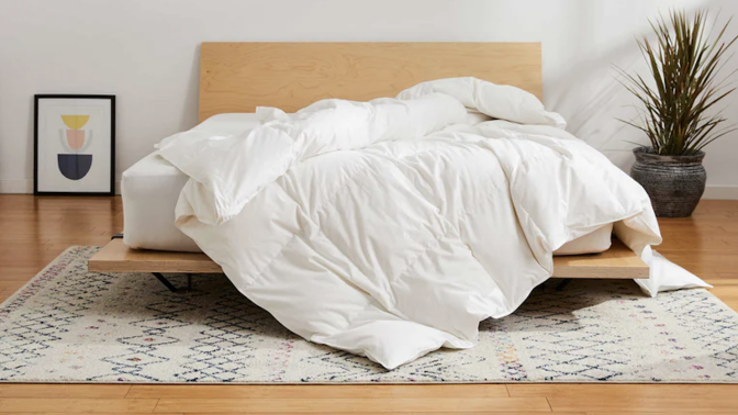 White duvet cover on a bed with a wooden bed frame