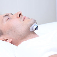 Person using the Snore Circle Anti-Snoring Sleep Aid Muscle Stimulator.