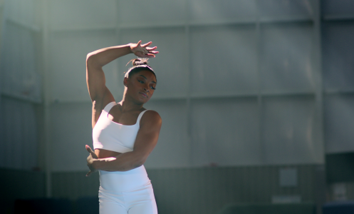 Simone Biles in a dance pose in a studio.