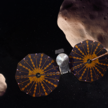 An artist's depiction of the Lucy spacecraft approaching Trojan asteroids.