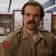 A man in a brown police uniform in a pharmacy.