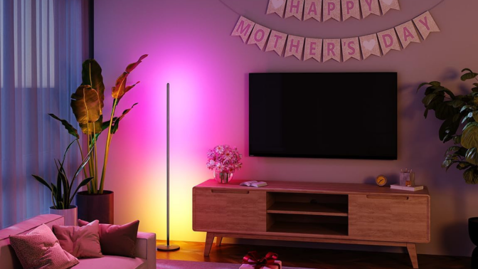 A Govee floor lamp radiating color onto a living room wall