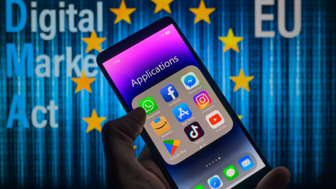 A phone displaying an applications folder in front of the European Union symbol. 