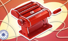 An illustration featuring a red Marcato Atlas manual pasta machine on a yellow and red graphic background.