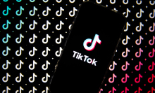 TikTok logo is displayed on a smartphone screen then replicated in pattern behind it.