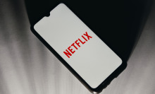 A phone screen displaying the Netflix logo.