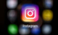 The Instagram app logo on a black blurred background