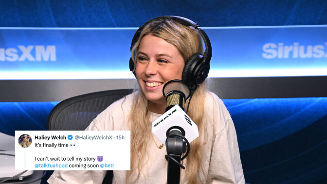 A woman sits in a studio wearing headphones and grinning.