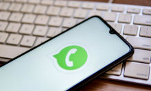 WhatsApp logo on phone screen set atop a keyboard