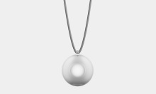 A smooth, round pendant with a small loop at the top, suspended from a textured, gray cord.