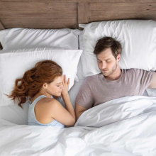man and woman sleeping on tuft & needle mattress in bedroom