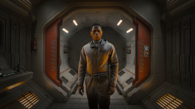 A man in a spacesuit stands in a spaceship hallway looking worried.