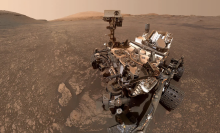 The dust-covered Curiosity rover exploring the Martian surface.