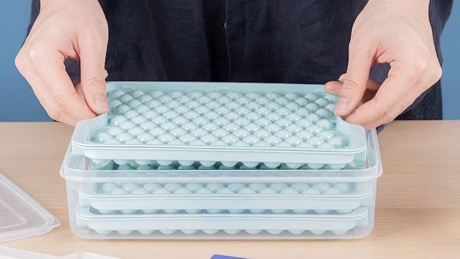 The Combler mini ice cube tray being held by a man inside the box that the tray comes with 