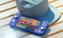 a blue nintendo switch lite resting against a cap